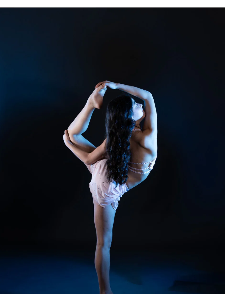 Advanced dancer performing under blue stage light